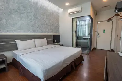 a bedroom with a large bed and a glass door at Indra Hotel Ipoh in Ipoh