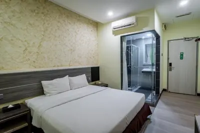 a hotel room with a bed and a shower at Indra Hotel Ipoh in Ipoh