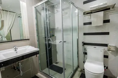 a bathroom with a shower and a toilet and a sink at Indra Hotel Ipoh in Ipoh