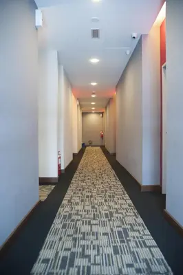 a hallway of an office building with a carpet at Indra Hotel Ipoh in Ipoh