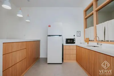 a white refrigerator in a kitchen with wooden cabinets at The Time Capsule 4B3B BY Verve 12 Pax in Ipoh