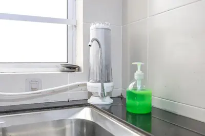 a sink with a bottle of green liquid next to a window at Comfort & Joy Family Homestay In Cameron Highland Clover Home 7-22 in Brinchang