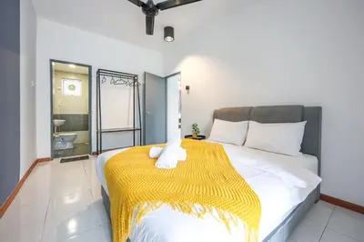 a bedroom with a bed with a yellow blanket on it at Comfort & Joy Family Homestay In Cameron Highland Clover Home 7-22 in Brinchang