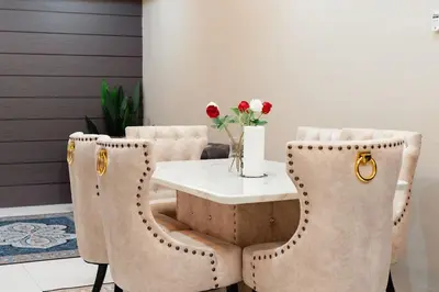 a dining room with a table and chairs with flowers at S&A Homestay in Sungai Petani