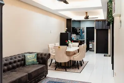 a living room with a couch and a table with chairs at S&A Homestay in Sungai Petani