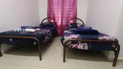 two beds in a room with purple curtains at D'SARRA Homestay Nibong Tebal in Nibung Tebal