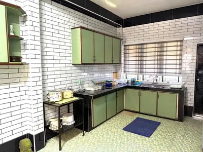 a kitchen with green cabinets and a white brick wall at Canning Garden-The Ipohscape in Ipoh