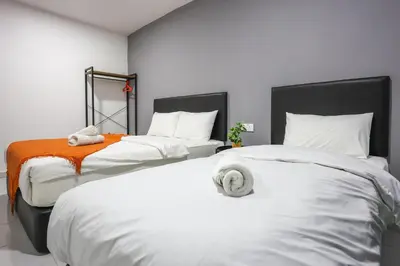 a bedroom with two beds with white sheets and an orange blanket at Family Retreat Cozy Stay in Brinchang Cameron Highlands Clover Home M-08 in Brinchang