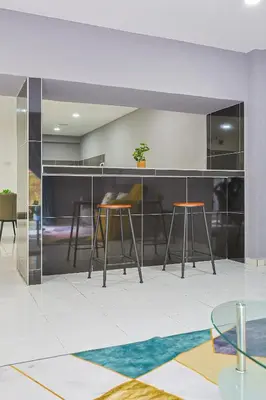 a living room with two stools and a counter at Family Retreat Cozy Stay in Brinchang Cameron Highlands Clover Home M-08 in Brinchang