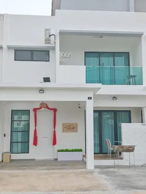 a white building with a red bow on the door at No 8 Homestay in Pangkor