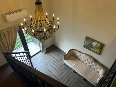 a living room with a couch and a chandelier at The Ranch in Ipoh