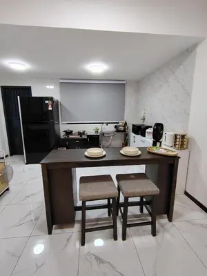 a kitchen with a large island with two chairs and a table at D Banyan Homestay, Sungai Petani, EV Friendly Stay, FREE 22kW in Sungai Petani