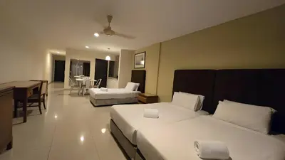 a hotel room with two beds and a dining room at Okay Marina Lumut Homestay in Lumut