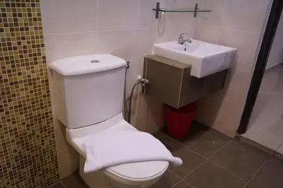 a bathroom with a white toilet and a sink at Okay Marina Lumut Homestay in Lumut