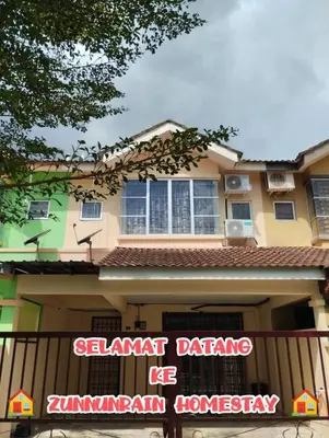 a building with a sign in front of it at Zunnurain Homestay in Kampong Batu Lapan