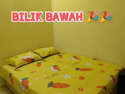 a bedroom with a bed with a yellow bedspread with cows on it at Zunnurain Homestay in Kampong Batu Lapan