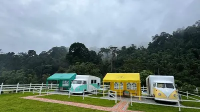 a group of three recreational vehicles parked in a field at The Starry Campervans Cameron Highlands in Cameron Highlands