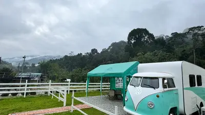 a blue and white truck parked next to a tent at The Starry Campervans Cameron Highlands in Cameron Highlands