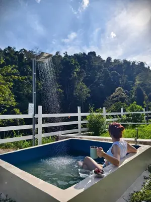 a woman sitting in a pool with a fountain at The Starry Campervans Cameron Highlands in Cameron Highlands