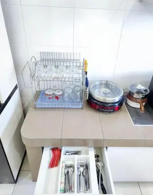 a kitchen counter with a shelf and utensils at Home in Ipoh in Ipoh