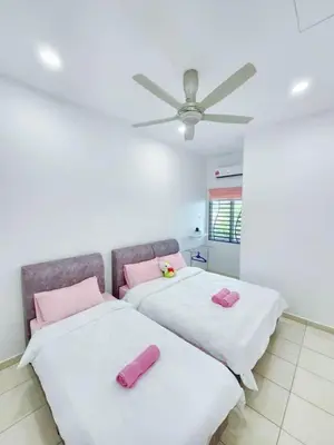 two beds in a room with pink pillows on them at Home in Ipoh in Ipoh