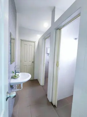 a white bathroom with a sink and a mirror at Home in Ipoh in Ipoh