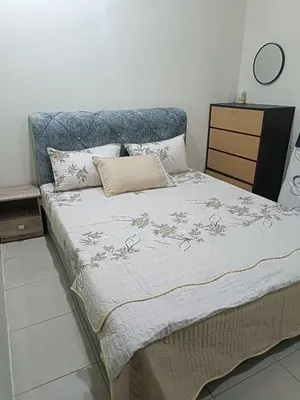 a bed with a blue headboard and pillows on it at Amirah homestay in Kampong Sungai Wangi Dalam