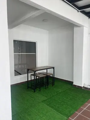 a table and chairs in a room with green grass at Mkm Villa cameron highland in Tanah Rata