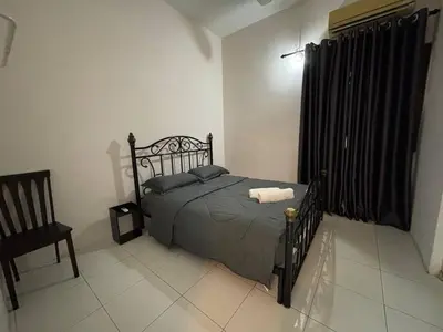 a bedroom with a bed and a chair at Comfy21 Homestay Ipoh in Ipoh