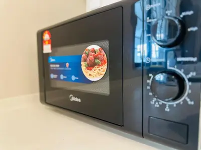 a microwave with a picture of a pizza inside at New Island Luxe Retreat Vacation Home 14pax Nearby Gurney in Tanjung Bungah