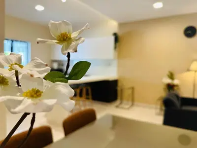 a vase with white flowers sitting on a table at New Island Luxe Retreat Vacation Home 14pax Nearby Gurney in Tanjung Bungah