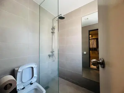 a bathroom with a toilet and a glass shower at New Island Luxe Retreat Vacation Home 14pax Nearby Gurney in Tanjung Bungah