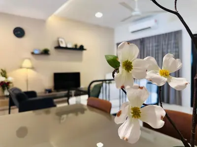 a table with white flowers in a living room at New Island Luxe Retreat Vacation Home 14pax Nearby Gurney in Tanjung Bungah