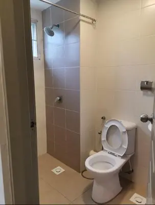 a bathroom with a white toilet and a shower at Ummu's homestay in Tanah Rata