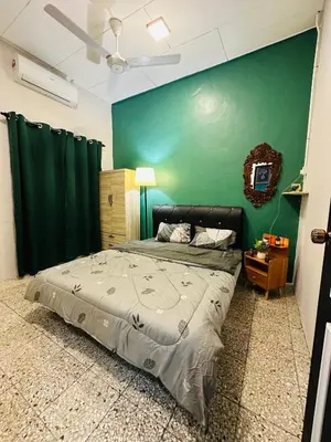 a bedroom with a bed with a green wall at M&M Bendi Homestay in Lunas
