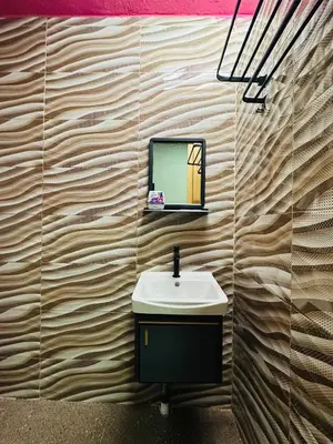 a bathroom with a sink and a tv on a wall at M&M Bendi Homestay in Lunas