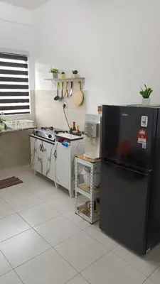 a kitchen with a black refrigerator and a stove at KhyraHomestay in Kampong Ayer Melintas Besar