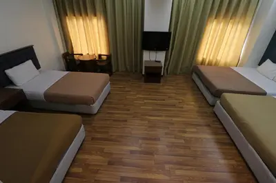 a hotel room with two beds and a television at Iris House Hotel Cameron Highlands in Brinchang