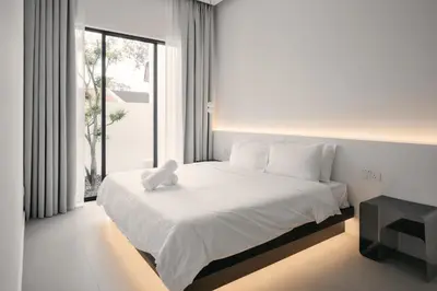 a white teddy bear sitting on a bed in a bedroom at Romantic Rooftop Jacuzzi Villa with Sunset Views in Jelutong