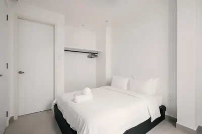a white bedroom with a white bed and a door at Romantic Rooftop Jacuzzi Villa with Sunset Views in Jelutong