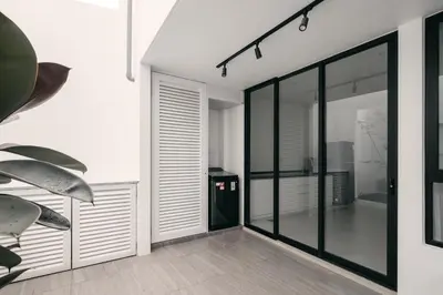 a hallway with black and white walls and glass doors at Romantic Rooftop Jacuzzi Villa with Sunset Views in Jelutong
