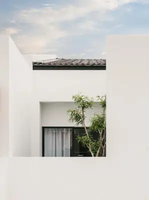 a white house with a tree in the window at Romantic Rooftop Jacuzzi Villa with Sunset Views in Jelutong