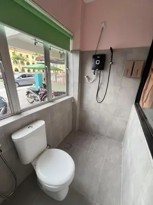 a small bathroom with a toilet and a shower at Hippo House Taiping in Taiping