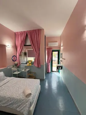 a bedroom with a bed and a table and a window at Hippo House Taiping in Taiping