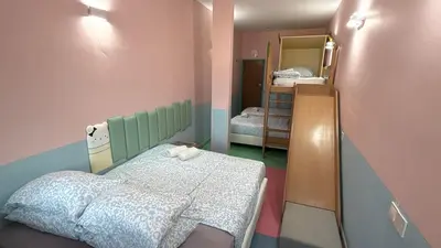 a small room with a bed and a mirror at Hippo House Taiping in Taiping