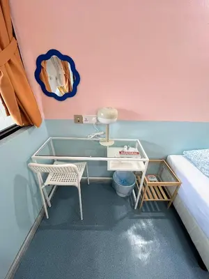a bedroom with a desk and a bed and a table and chairs at Hippo House Taiping in Taiping