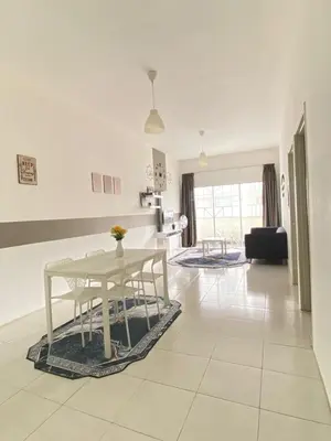 a white living room with a table and a couch at Wan AyuRa Homestay in Tanah Rata
