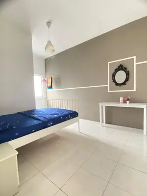 a room with a bed and a table in it at Wan AyuRa Homestay in Tanah Rata