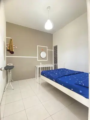 a bedroom with a bed and a table in it at Wan AyuRa Homestay in Tanah Rata