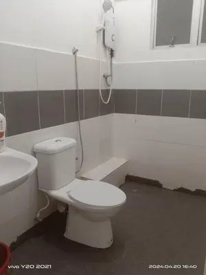 a bathroom with a toilet and a phone on the wall at Wan AyuRa Homestay in Tanah Rata